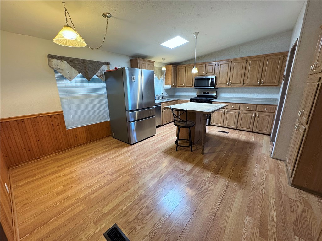 14224 East Randy Ranch Road Kingman, AZ 86401 - Photo 10 of 75 The kitchen features wood cabinetry, a central island, and stainless steel appliances including a refrigerator, microwave, and range