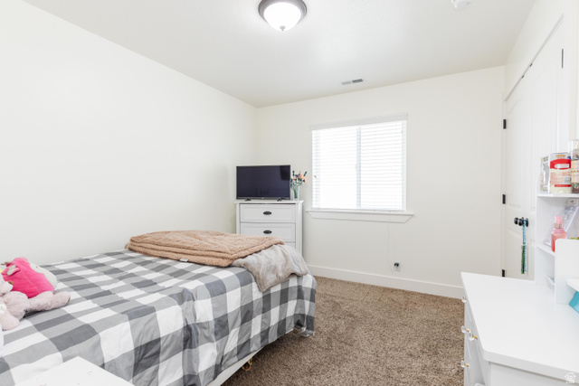 1145 West 2640th Street South Logan, UT 84321 - Photo 11 of 17 Neutral-toned room featuring a single window with blinds, light-colored walls, and carpet flooring