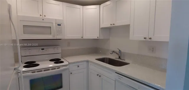 a kitchen with white cabinets and white appliances