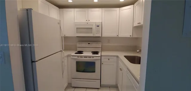 a kitchen with cabinets and white stainless steel appliances