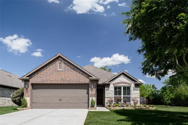a front view of a house with a garden and plants