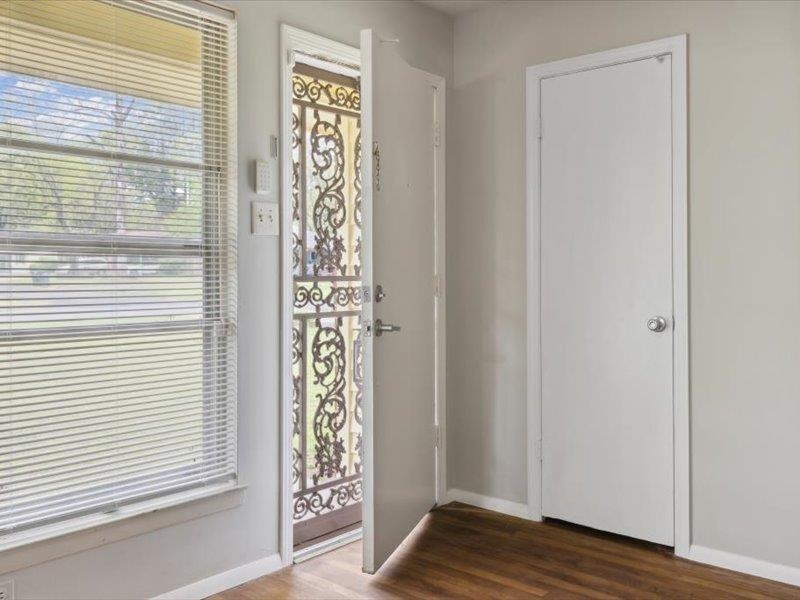 1599 Butterworth Road Memphis, TN 38116 - Photo 6 of 26 a view of an empty room with wooden floor and a window