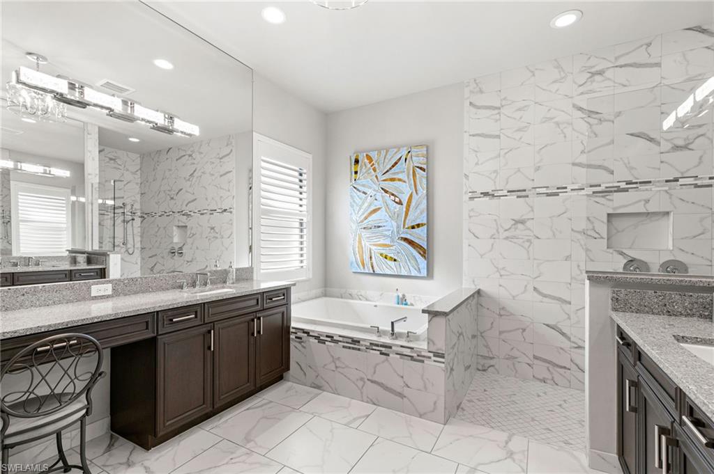 4366 Caldera Circle Naples, FL 34119 - Photo 12 of 41 a bathroom with a granite countertop sink a toilet a mirror and bathtub