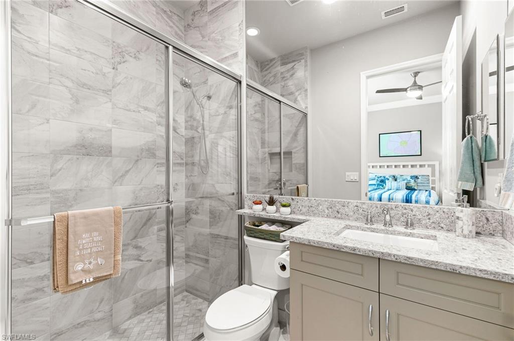 4366 Caldera Circle Naples, FL 34119 - Photo 24 of 41 a bathroom with a granite countertop sink mirror vanity and toilet