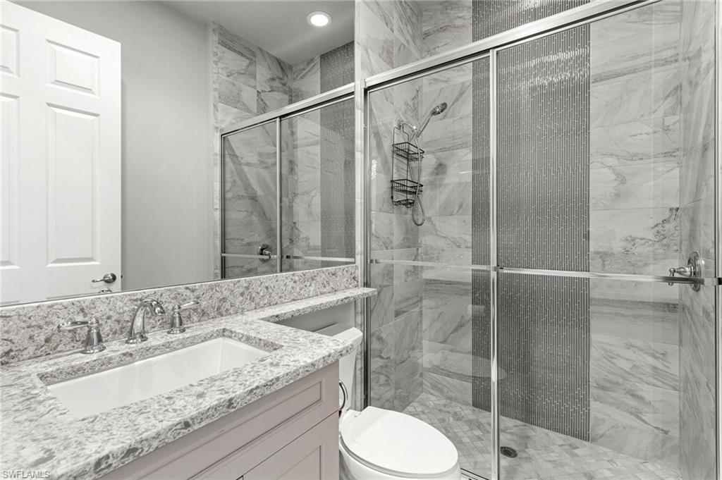 4366 Caldera Circle Naples, FL 34119 - Photo 26 of 41 a bathroom with a granite countertop sink toilet and shower
