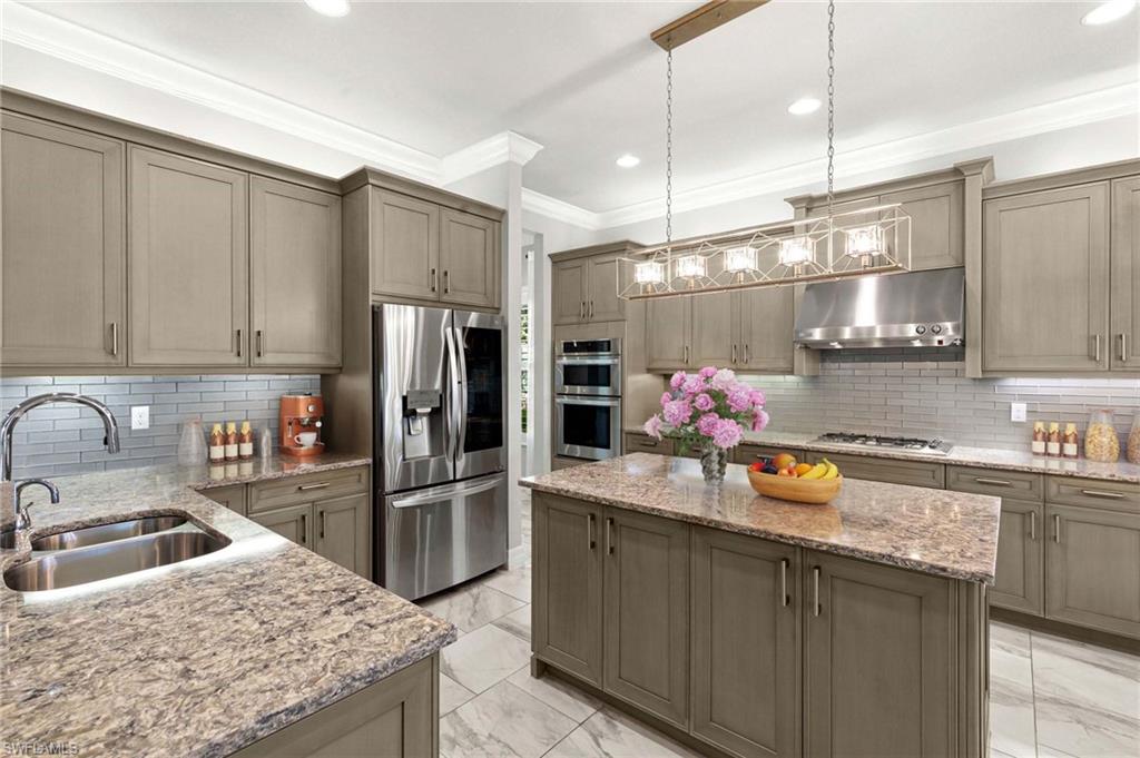 4366 Caldera Circle Naples, FL 34119 - Photo 5 of 41 a kitchen with stainless steel appliances granite countertop a sink refrigerator and cabinets