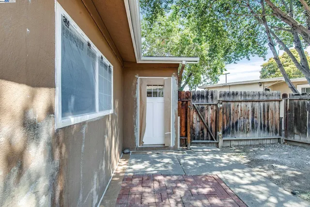 a view of a small house with wooden fence