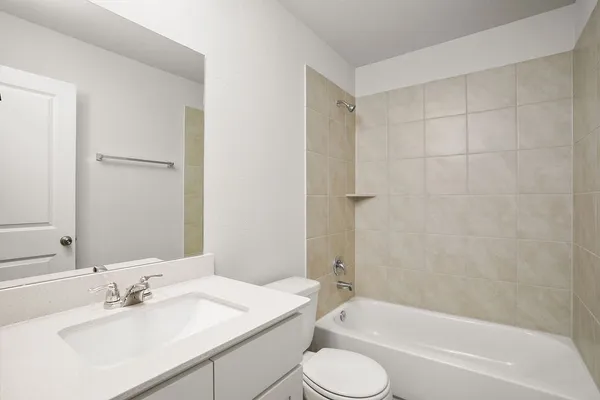 a bathroom with a tub sink vanity and a mirror