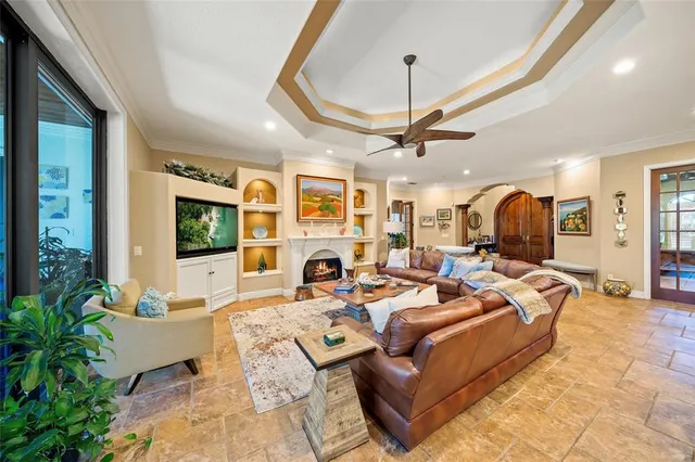 a living room with furniture a fireplace and a chandelier