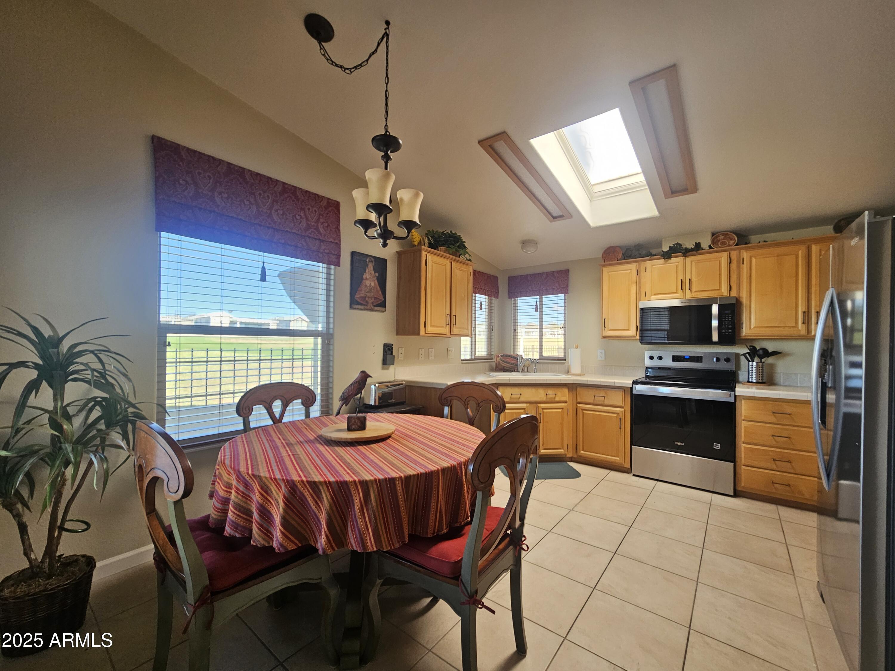 650 North Hawes Road, Unit 4820 Mesa, AZ 85207 - Photo 7 of 54 a kitchen with stainless steel appliances granite countertop a stove a sink dishwasher a dining table and chairs with wooden floor