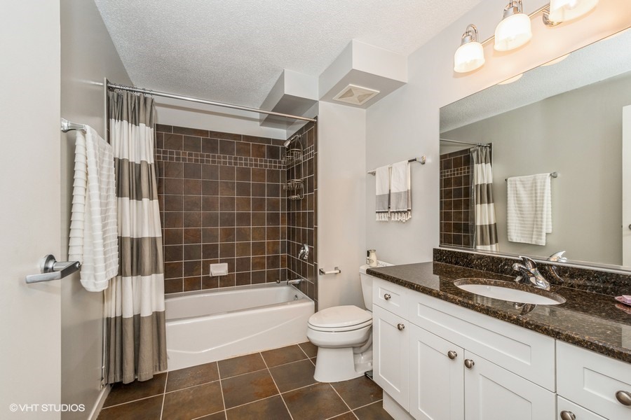 800 Elgin Road, Unit 517 Evanston, IL 60201 - Photo 15 of 20 a bathroom with a double vanity sink toilet mirror and shower