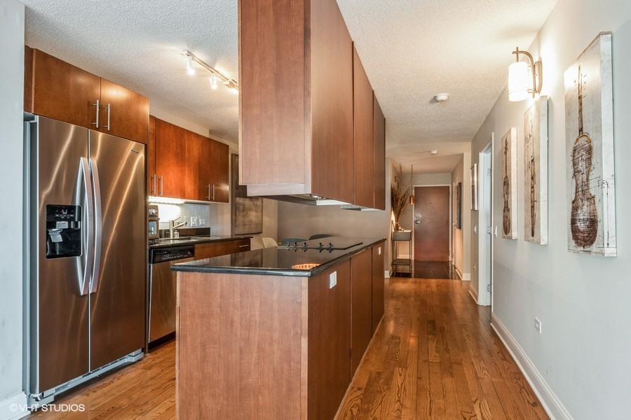 800 Elgin Road, Unit 517 Evanston, IL 60201 - Photo 8 of 20 a kitchen with stainless steel appliances granite countertop a refrigerator a stove and a wooden floors