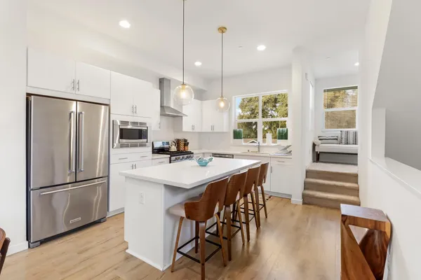 a kitchen with a sink a stove cabinets and wooden floor