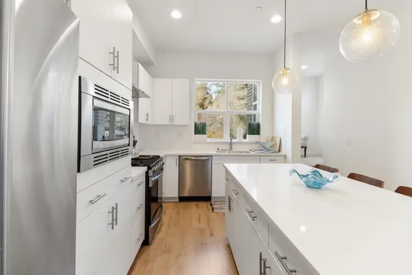 a large white kitchen with a table and chairs