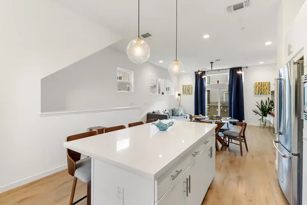 a kitchen with stainless steel appliances a stove a table a sink refrigerator and cabinets