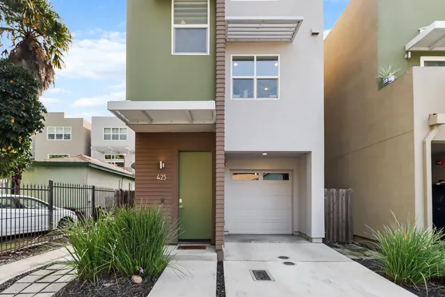 a view of a house with many windows and plants
