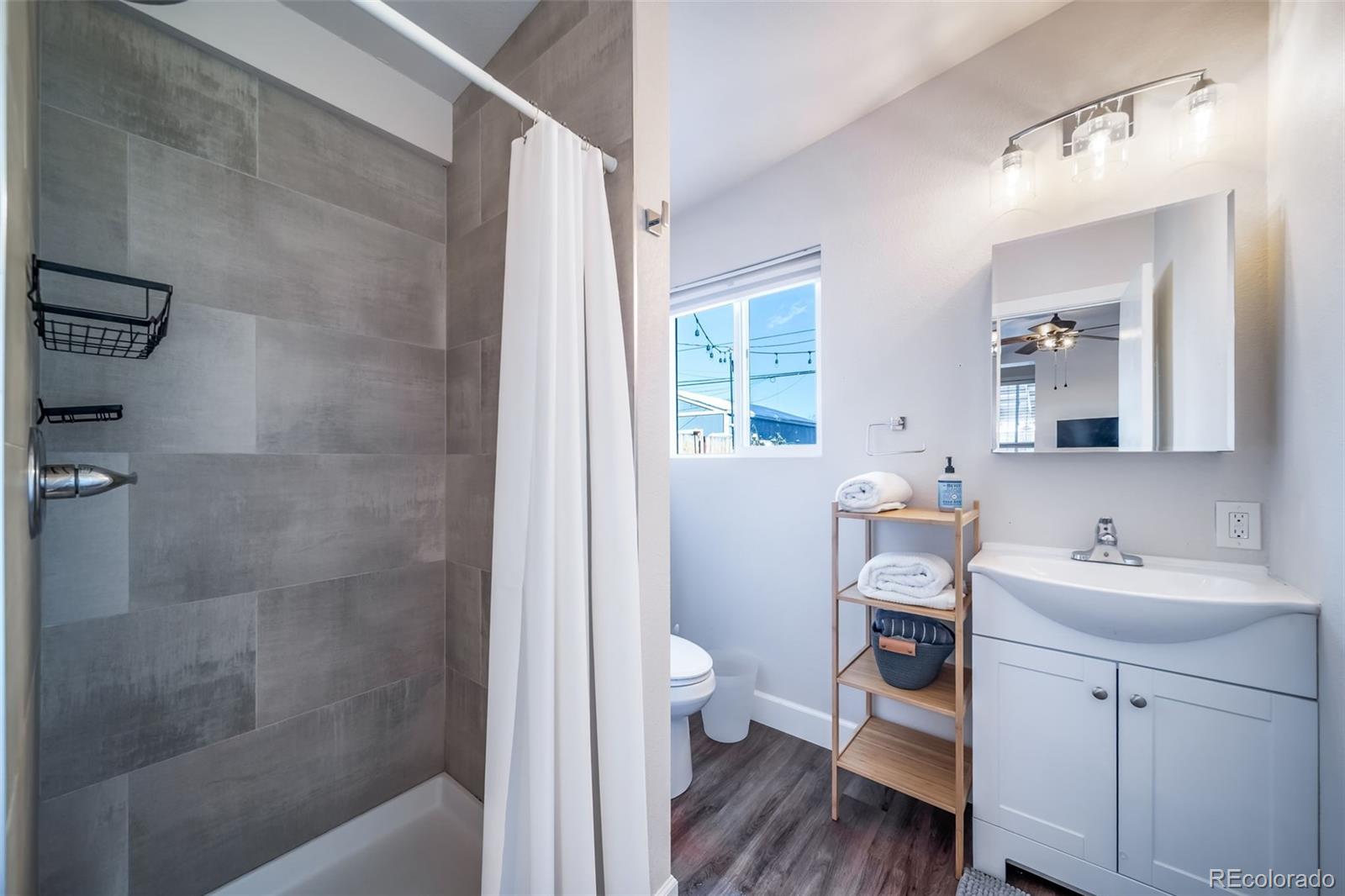 3536 North Williams Street, Unit 1 5 Denver, CO 80205 - Photo 8 of 15 a bathroom with a sink a toilet a mirror and shower