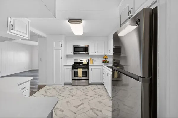 a kitchen with granite countertop a refrigerator and a sink