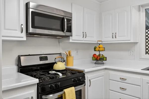 a kitchen with white cabinets and black appliances
