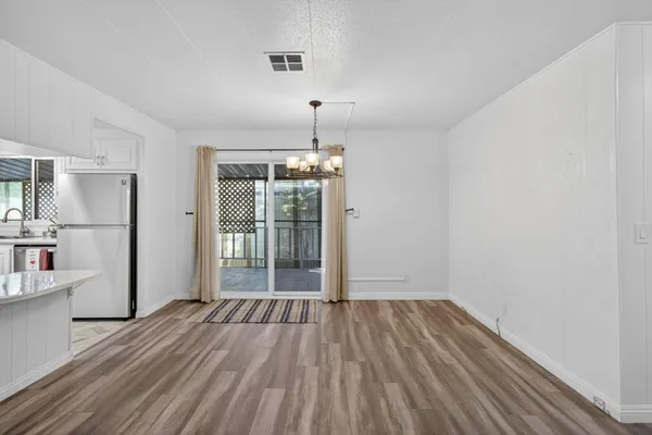 a view of kitchen and hall with wooden floor