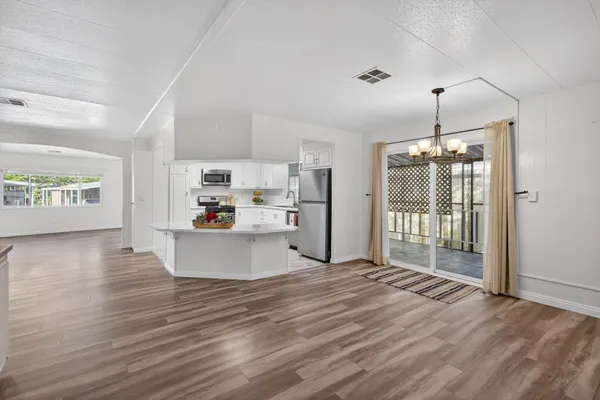 a view of kitchen and living room with wooden floor