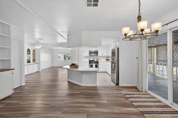 a view of a living room and kitchen with wooden floor