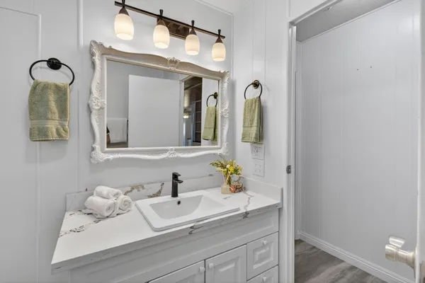a view of an empty room with wooden floor and window