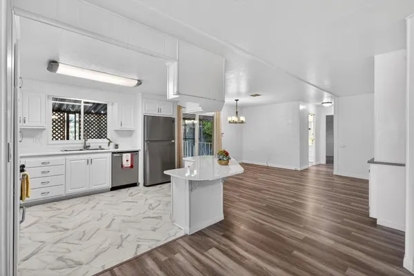 a view of a kitchen with wooden floor and electronic appliances