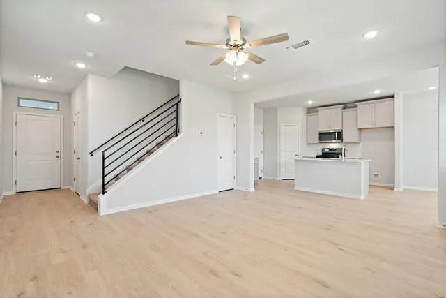 a view of a kitchen with a sink and a ceiling fan