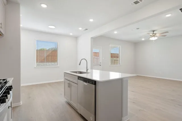 a kitchen with stainless steel appliances granite countertop a sink a stove a microwave and island