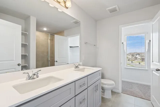 a bathroom with a granite countertop sink a toilet and a mirror