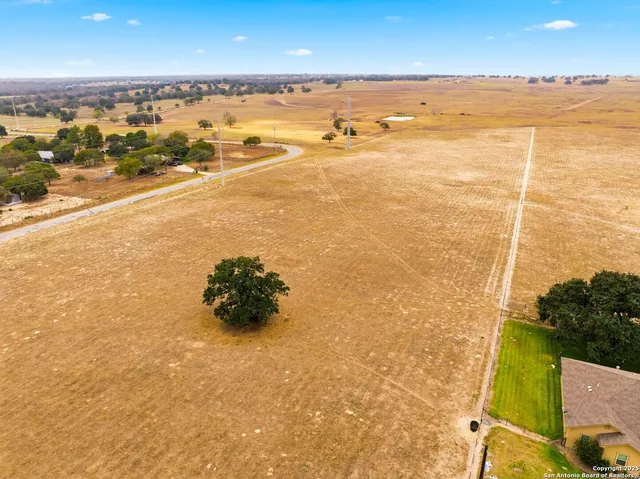 a view of a yard with wooden fence