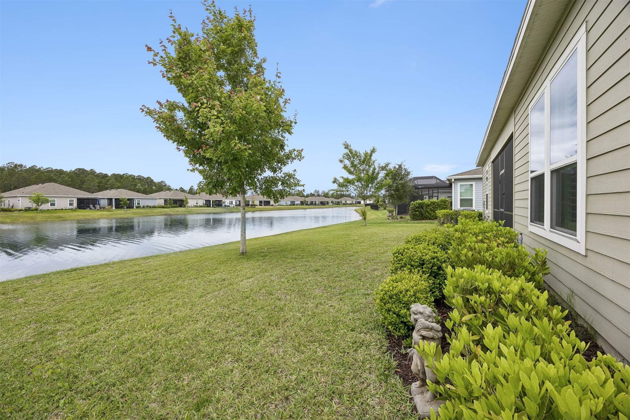 75133 Pondside Lane Yulee, FL 32097 - Photo 37 of 65 a view of a lake with a house in the background