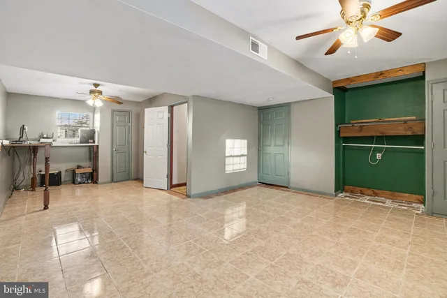 a view of an empty room with a chandelier fan