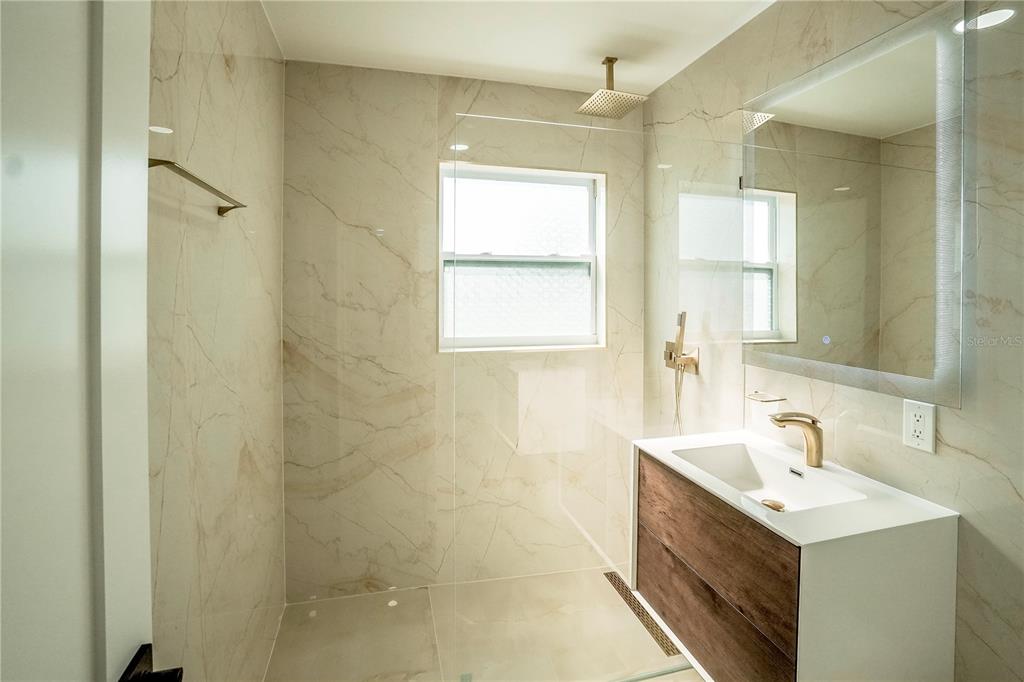 6821 Marius Road North Port, FL 34287 - Photo 24 of 39 a bathroom with a sink a vanity a window and a mirror