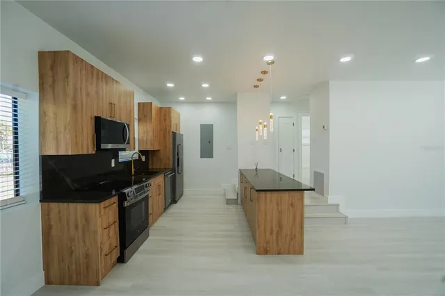 a kitchen with stainless steel appliances granite countertop a stove and a refrigerator