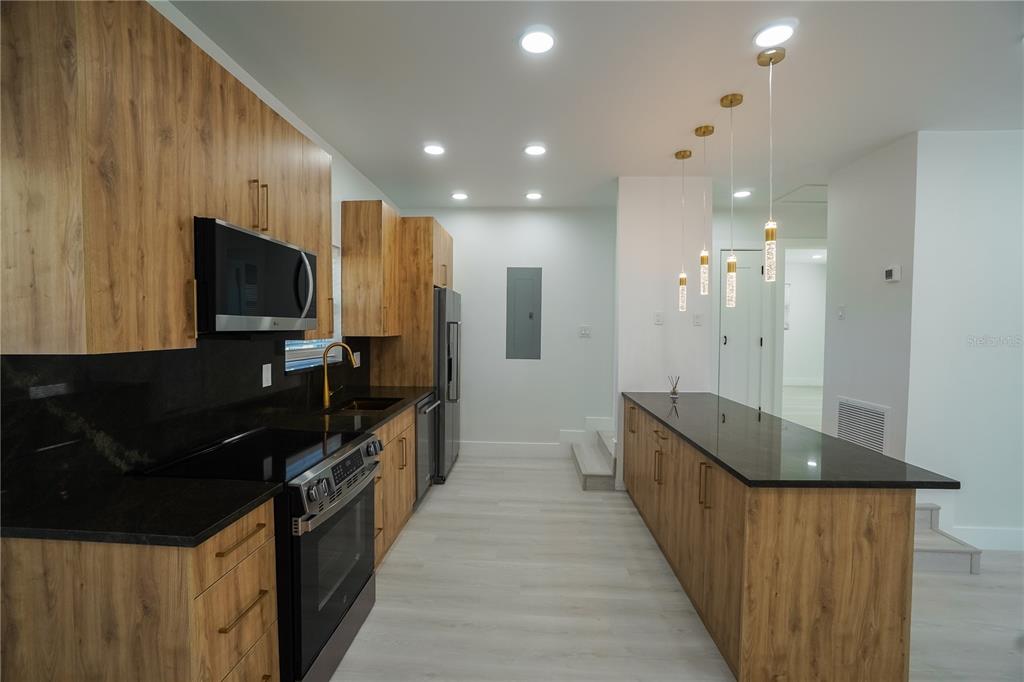 6821 Marius Road North Port, FL 34287 - Photo 9 of 39 a kitchen with granite countertop a sink and a stove top oven