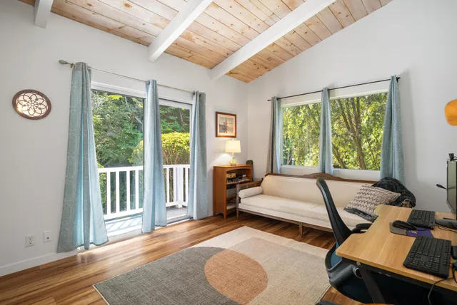 a bed room with a bed and two window