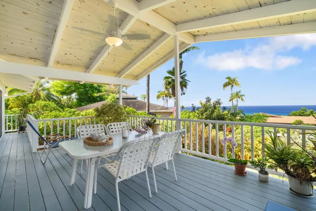a view of a balcony with chairs and wooden floor