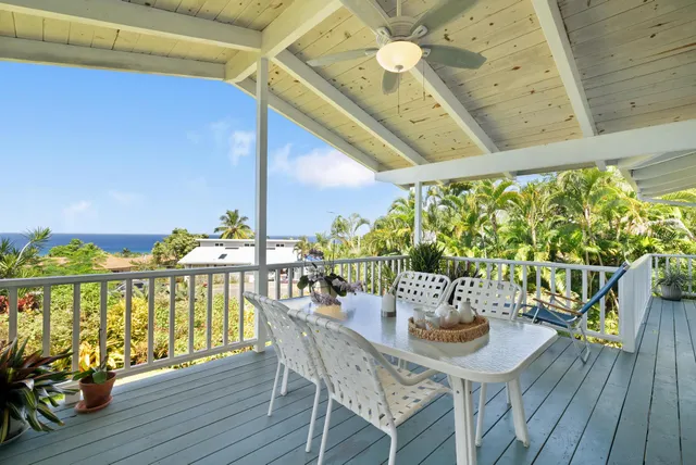 a view of a balcony with chairs and wooden floor