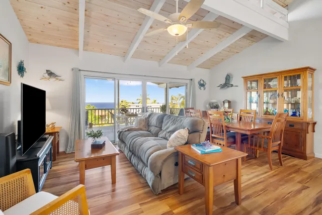 a living room with furniture kitchen view and a large window