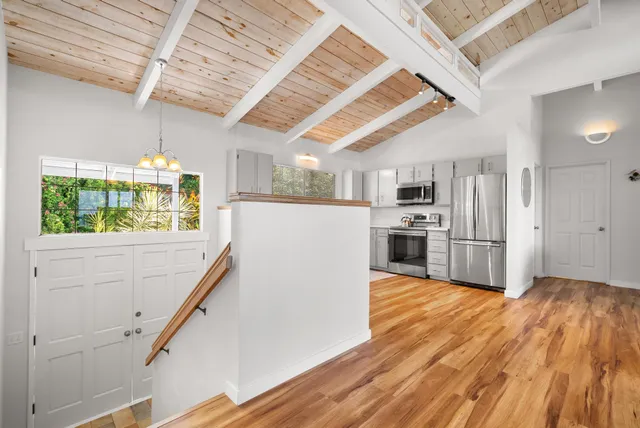 a kitchen with stainless steel appliances wooden floors and wooden floors