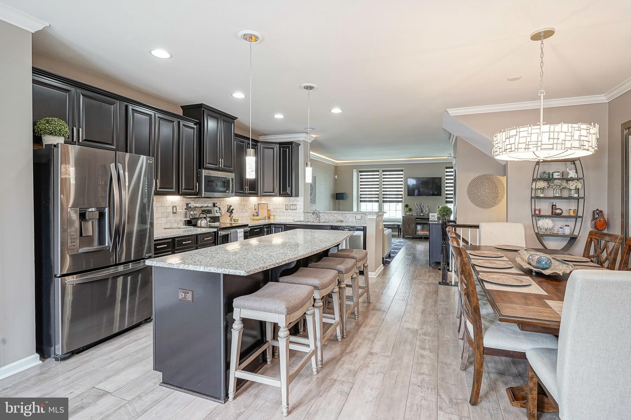 1056 Prime Place Sewell, NJ 08080 - Photo 19 of 41 a kitchen with stainless steel appliances granite countertop a table chairs refrigerator and a sink