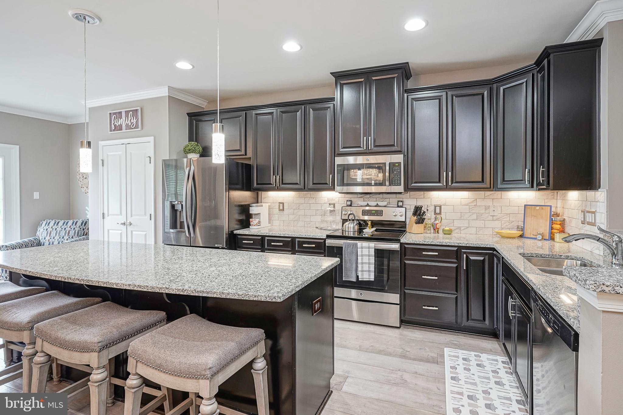 1056 Prime Place Sewell, NJ 08080 - Photo 10 of 41 a kitchen with stainless steel appliances granite countertop a stove top oven a refrigerator a sink and chairs