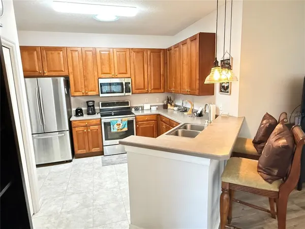 a kitchen with a refrigerator a stove a sink dishwasher and microwave with wooden cabinets
