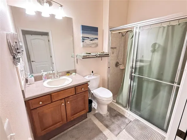 a bathroom with a granite countertop sink toilet and shower