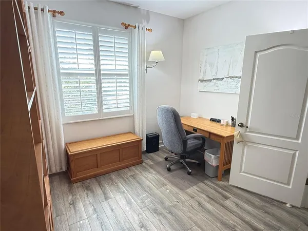 a view of a workspace with furniture and a window