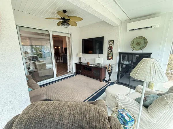 a living room with furniture a flat screen tv and a large window
