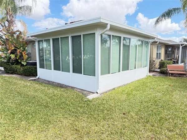 a view of a white house with a yard and large tree