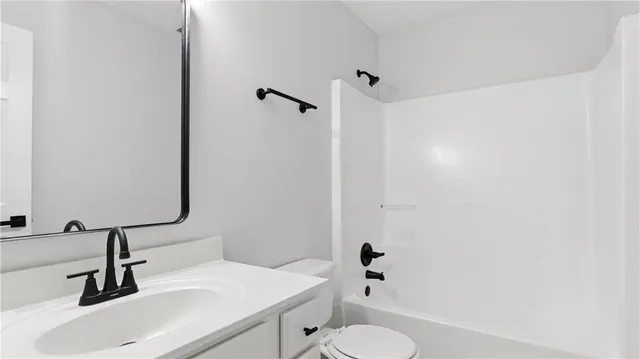 a bathroom with a sink toilet and a mirror